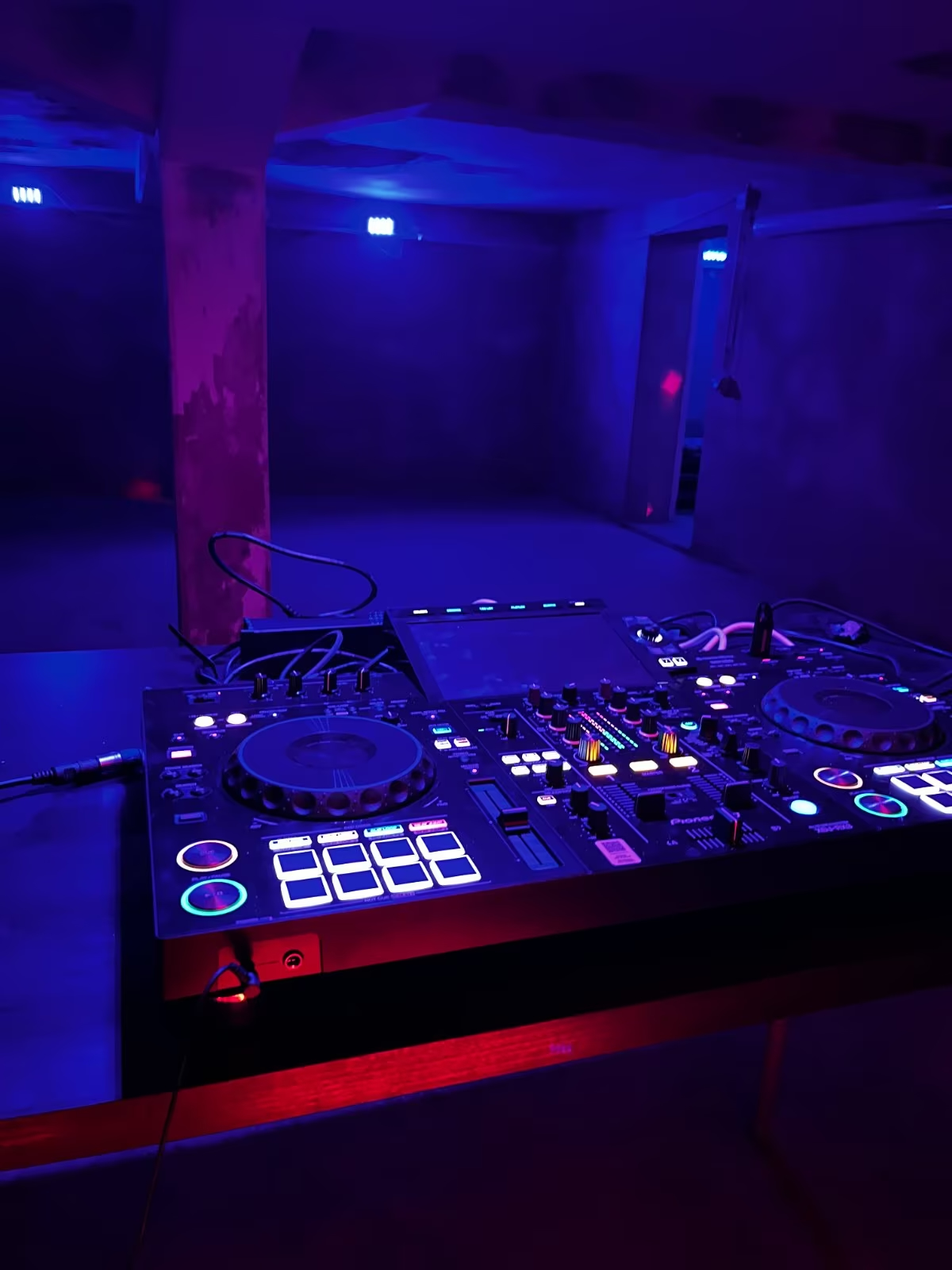 DJ-Pult mit Clublicht und Neon-Atmosphäre